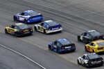 Rear view of NASCAR Cup Series cars of Kyle Larson, Christopher Bell and more racing in a pack at Nashville Superspeedway, NKP