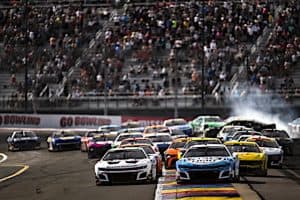 Ross Chastain pack racing in a turn at Watkins Glen as there's a spin in the back, NKP