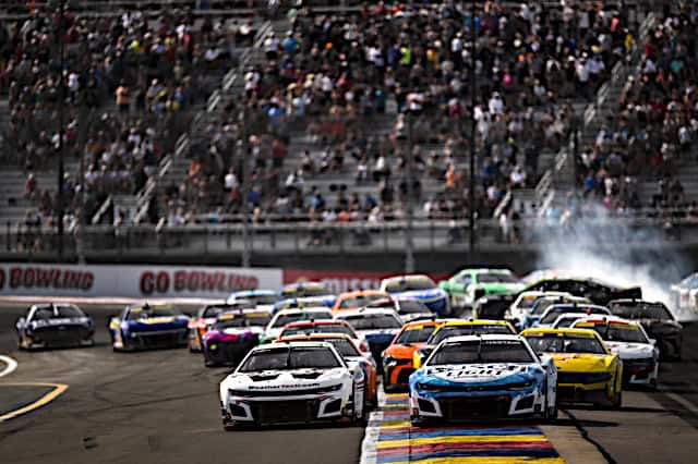 Ross Chastain pack racing in a turn at Watkins Glen as there's a spin in the back, NKP