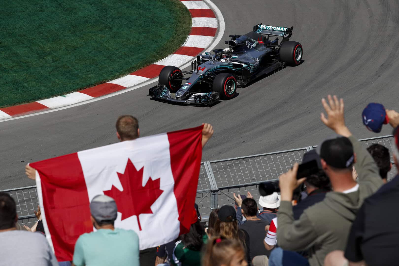 A fan holds the Canadian flag during the 2018 F1 Canadian Grand Prix.
