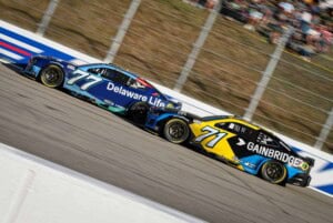 2025 Cup New Hampshire side-by-side racing II - Spire Motorsports teammates Carson Hocevar, No. 77 Chevrolet, and Michael McDowell, No. 71 Chevrolet (Credit: Chase Folsom)